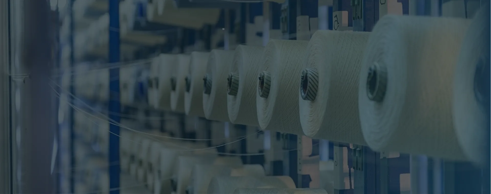 Yarn spools on textile manufacturing machinery in Shreeji Yarn facility